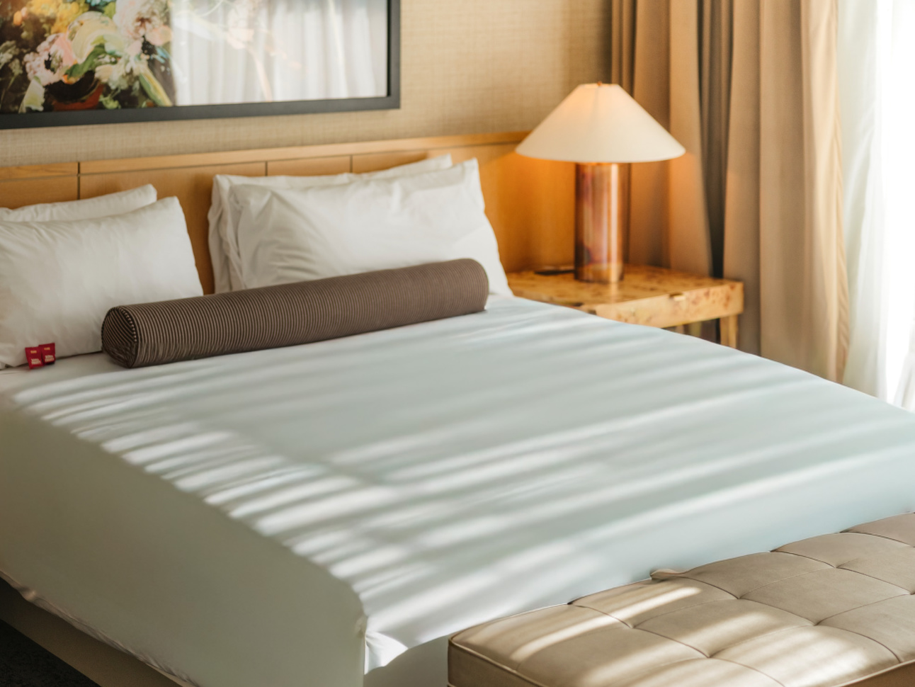 Bed with side table and lamp in a renovated 21c Suite
