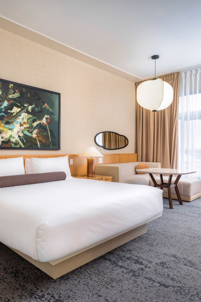 Bed with seating area in renovated Luxury King room at 21c Bentonville