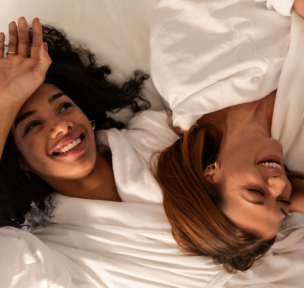 A couple snuggling on a hotel bed