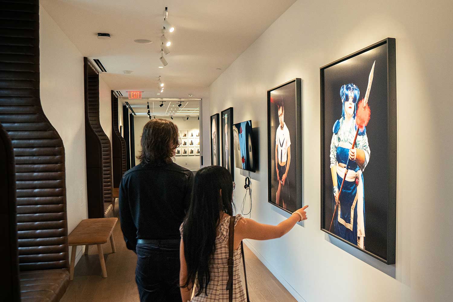 Two people looking at photography in the "Dress Up, Speak Up" exhibition at 21c Museum Hotel St. Louis