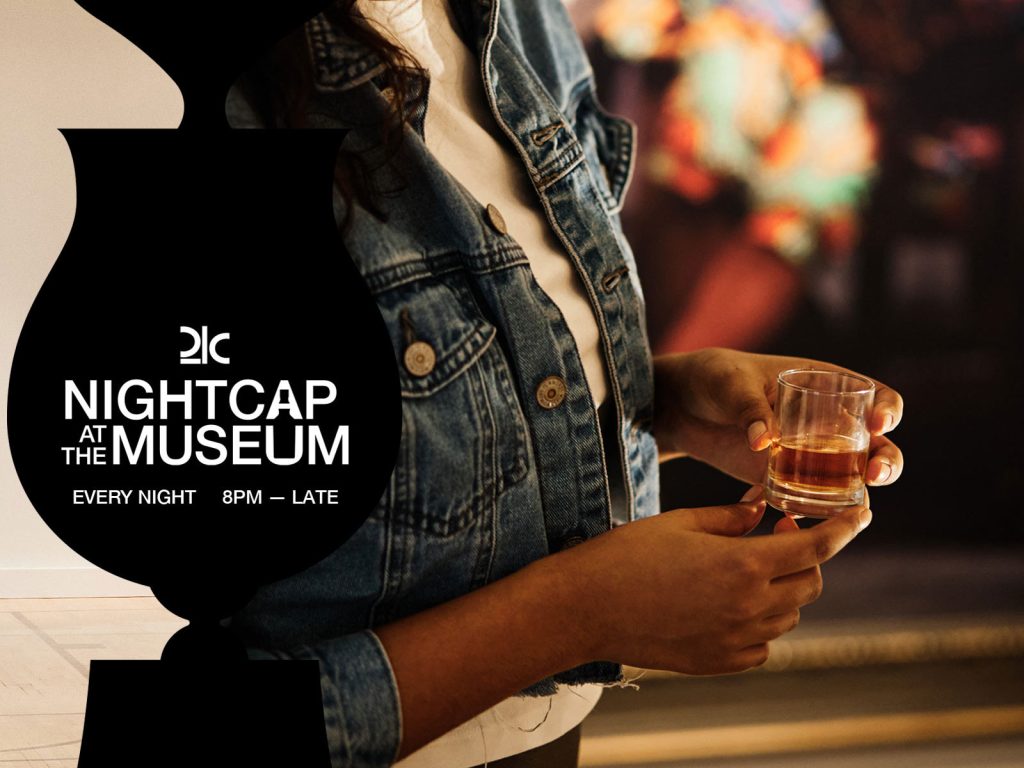 Woman holding a glass of bourbon for the 8pm Nightcap at the Museum event.