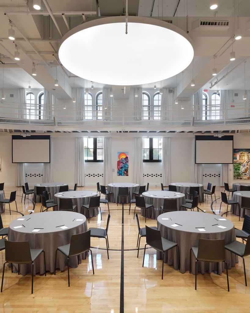 A grand event space with round tables set up for a meeting