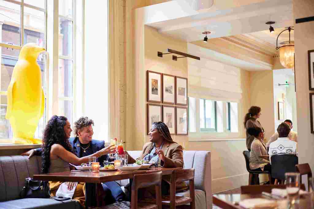 People at a dinner table clinking drinks