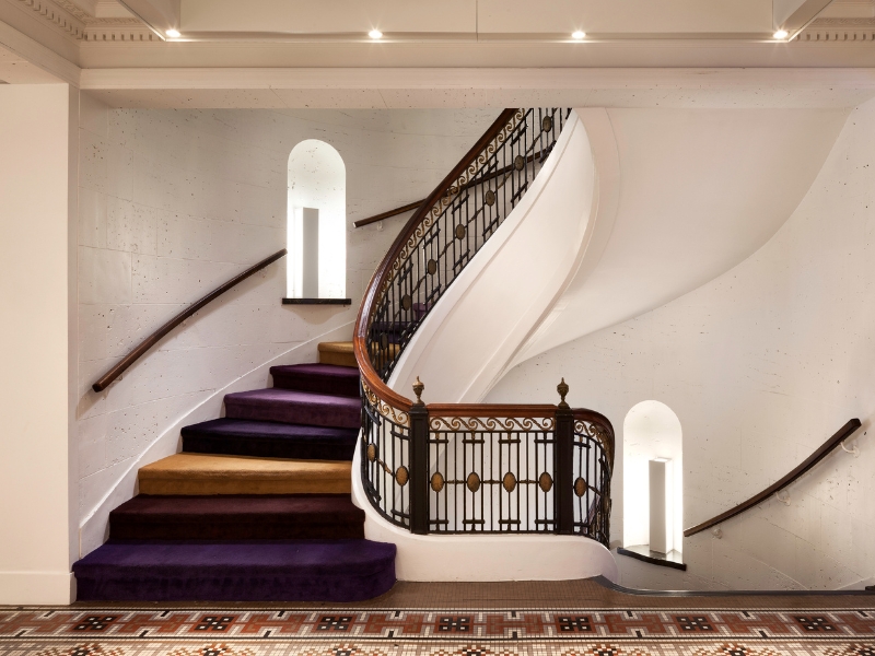 Yellow and purple curved staircase with fancy railing