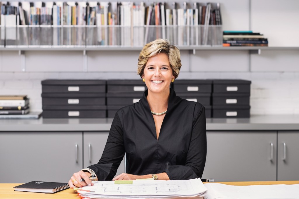 Woman in black shirt smiles at the camera in an office setting