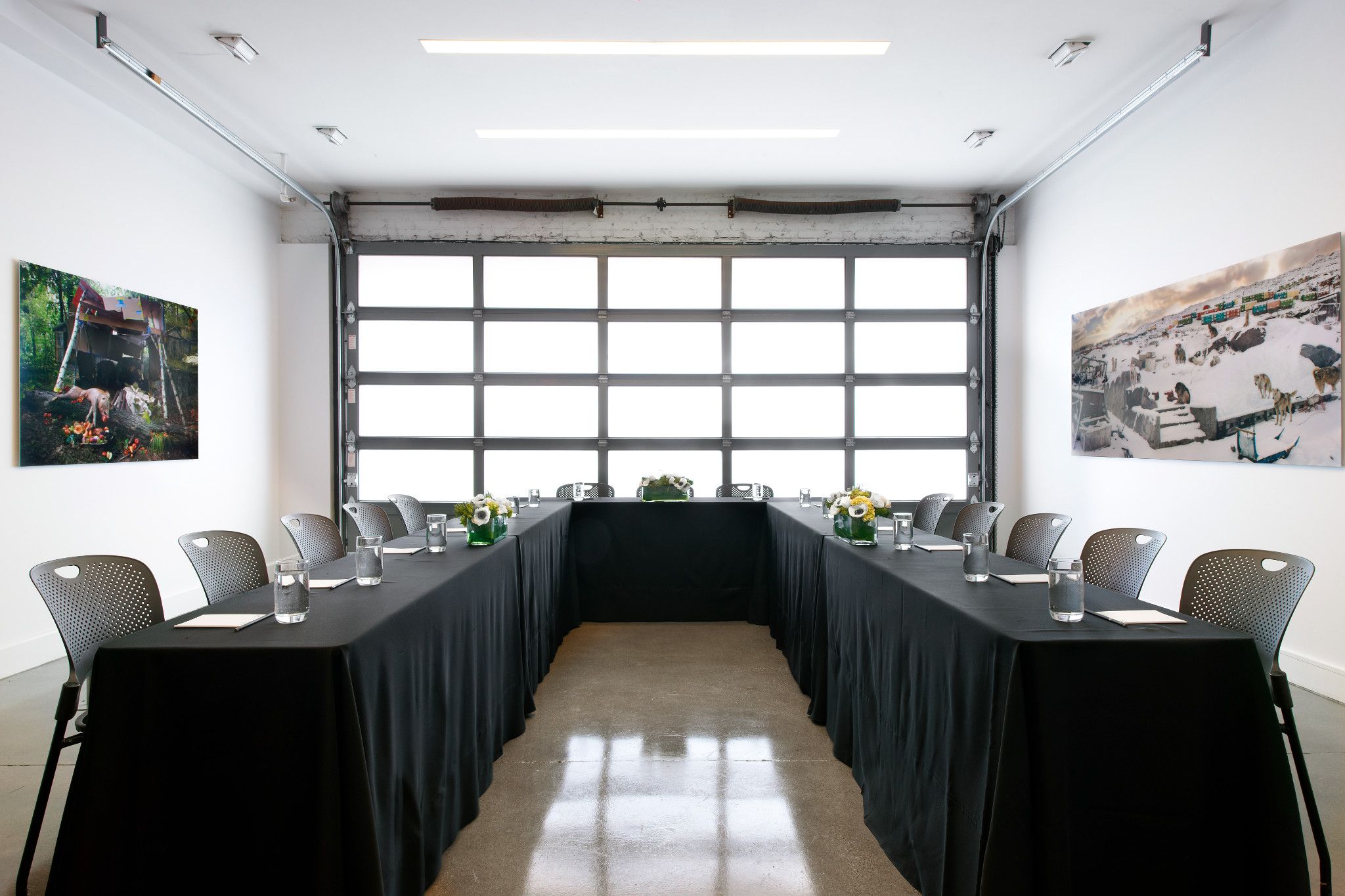 A small art gallery space set up for an meeting with conference table and chairs