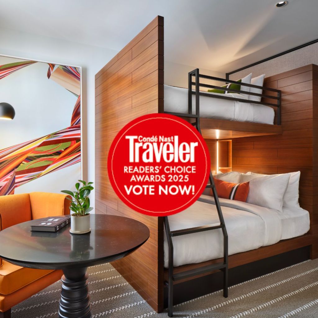 Large wooden bunk beds, small black table, and orange chair