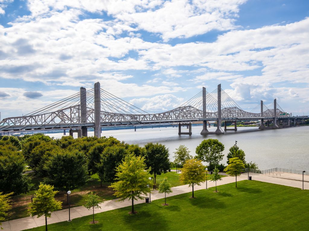 Aerial photo of Louisville's beautiful Waterfront Park and the Ohio River with commuter bridge in the background.