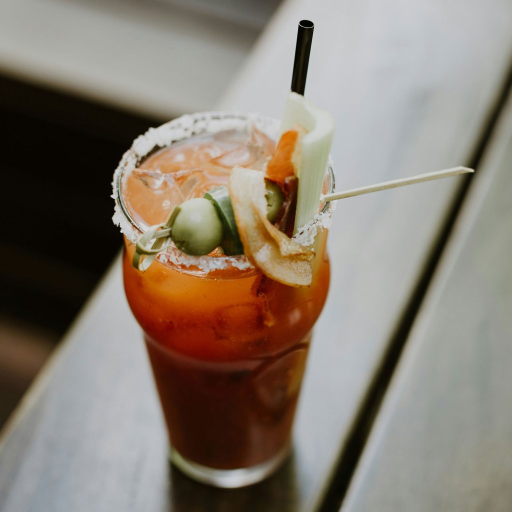 Bloody Mary cocktail topped with pickles and lime garnish
