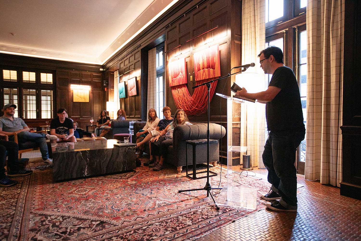 A man performs spoken word poetry to a crowd in the Billiards Room at 21c Museum Hotel St. Louis