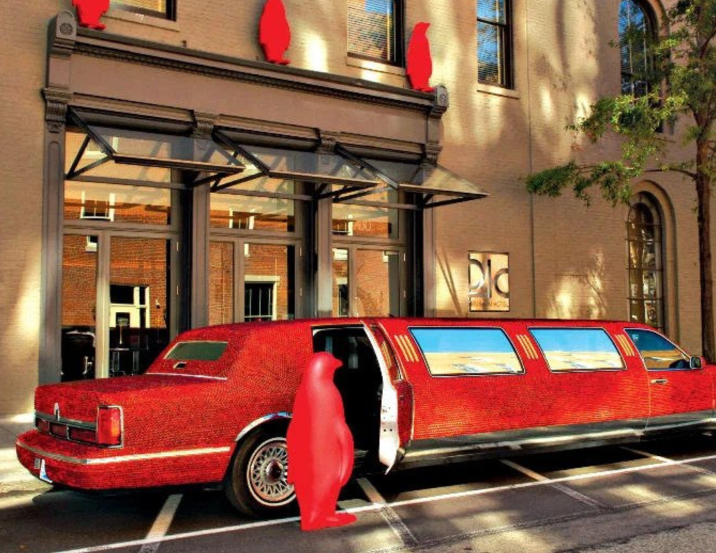 Cracking art penguin standing outside 21c Louisville next to the "Art Car" limousine.