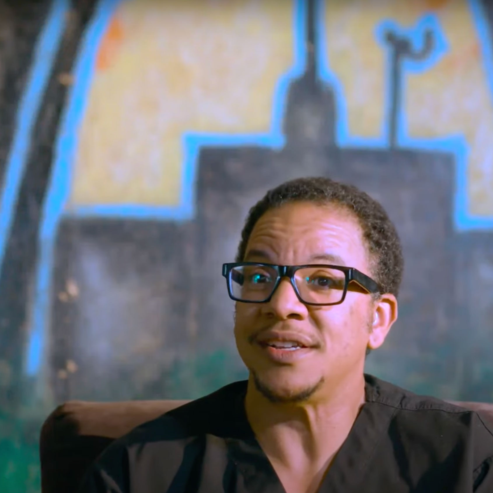 A man speaks in front of a St. Louis mural in the documentary "Every Bullet Leaves A Mark"