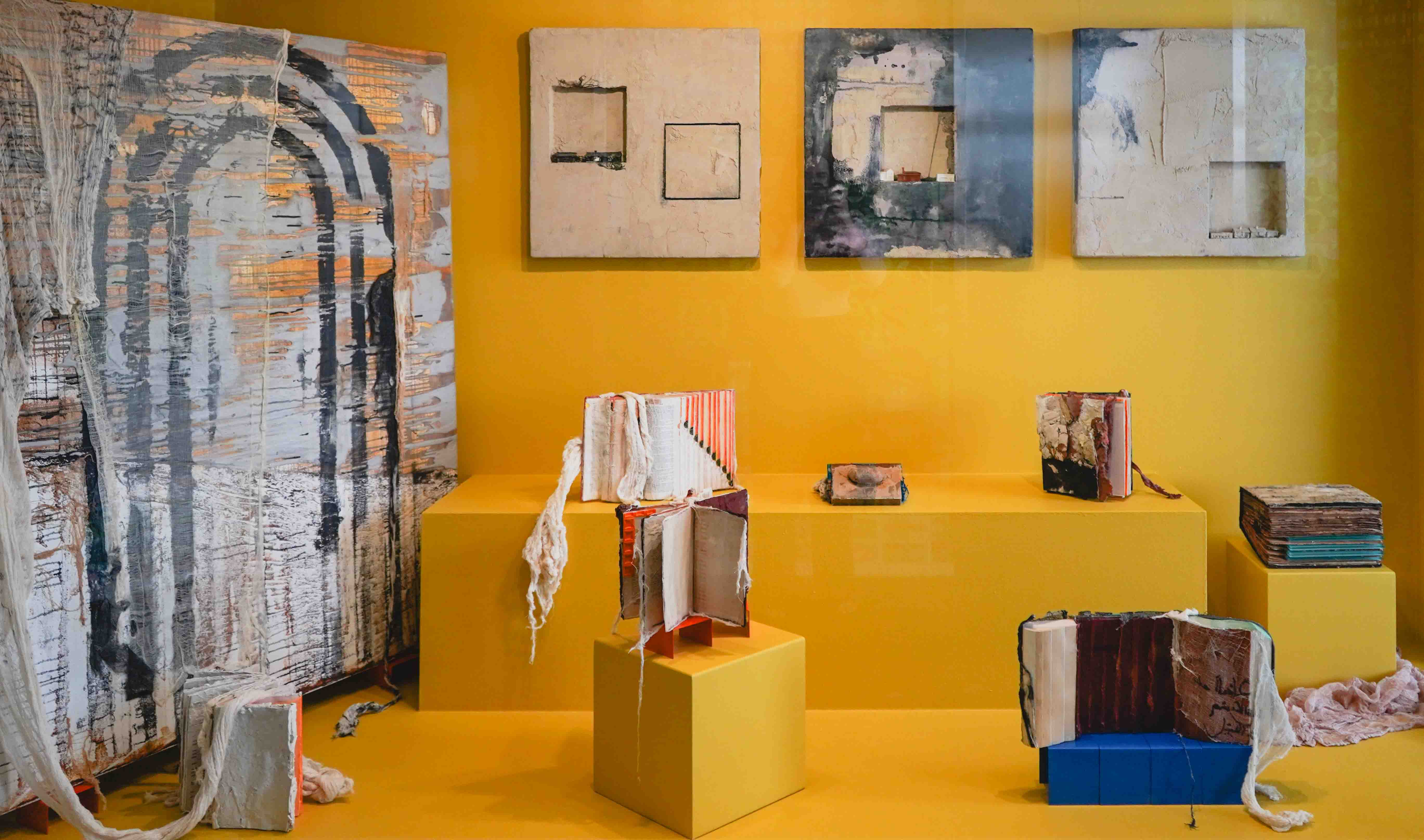 sculptures and paintings with a yellow backdrop