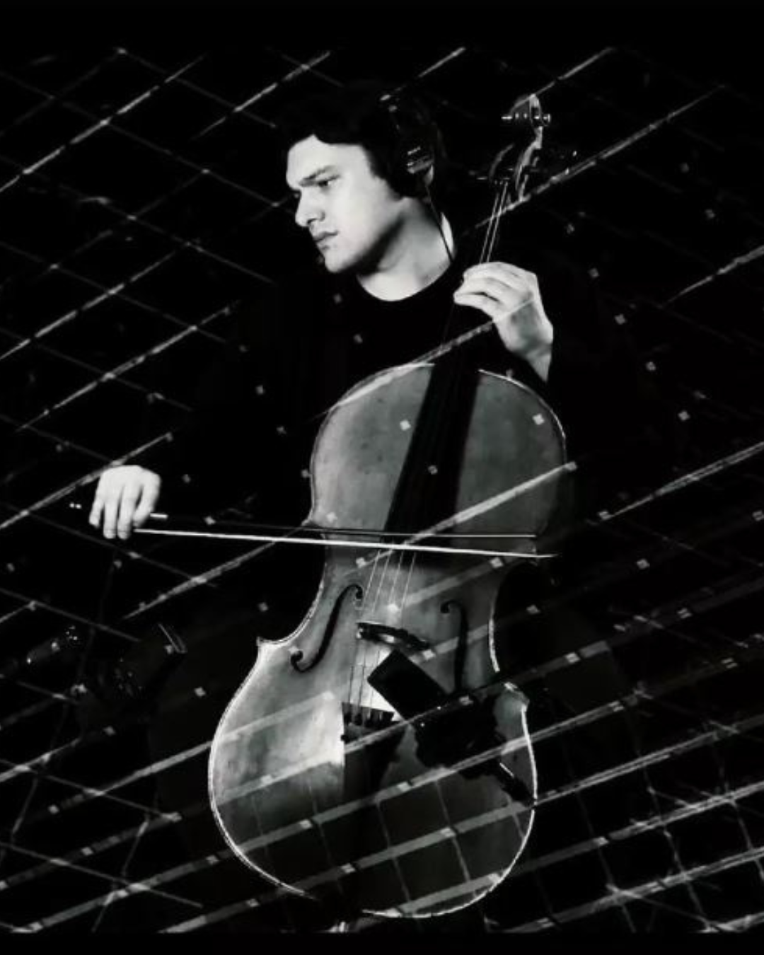 black and white photo of man playing cello