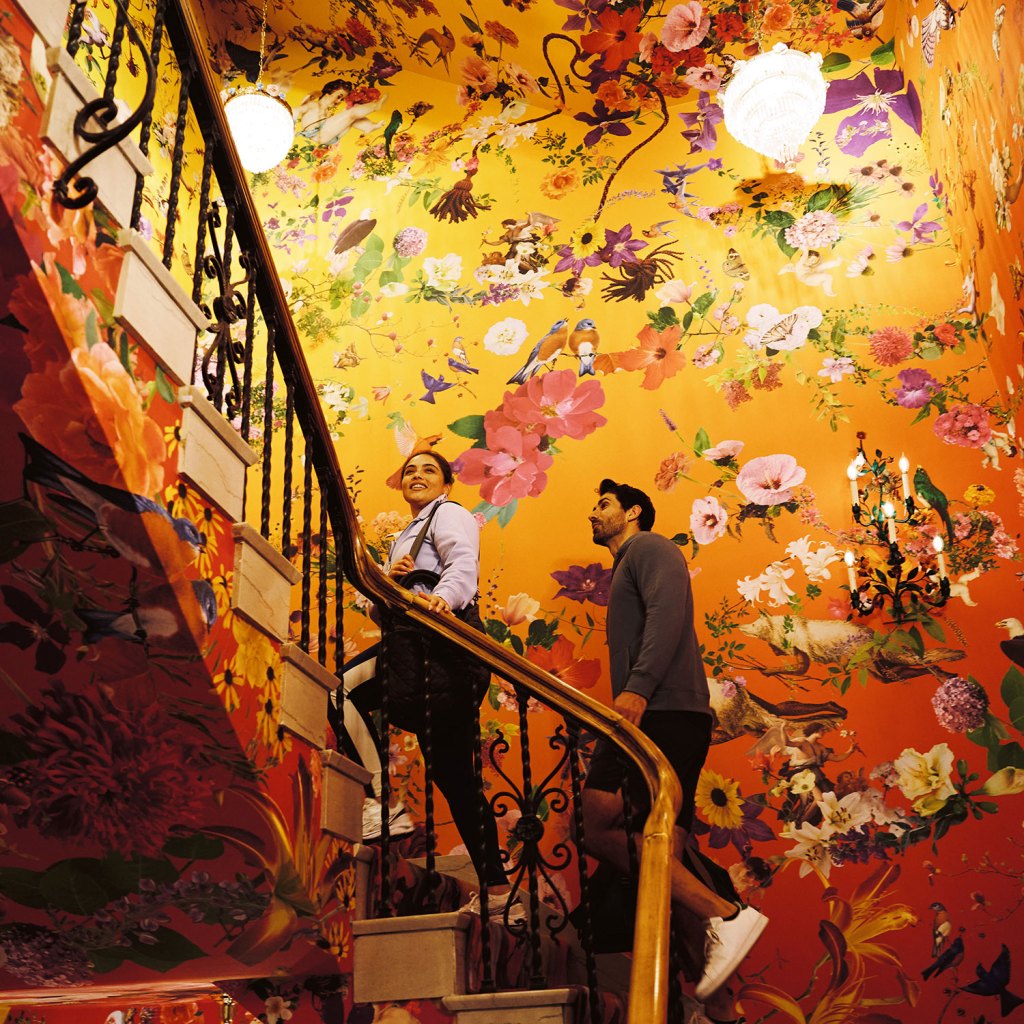 A couple walking up the Fallen Fruit staircase at 21c Museum Hotel St. Louis