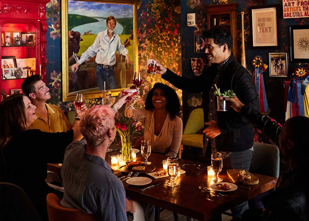 A group of friends cheersing in the private dining room at Proof on Main restaurant