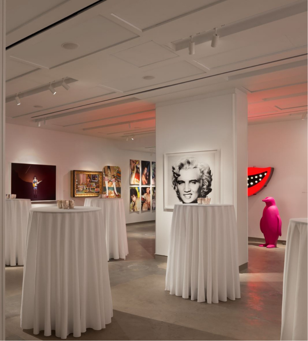Gallery with art on walls and round tables